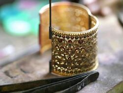 Goldsmith Jeweler use gasoline burner melting and decorating bracelet Stock Footage