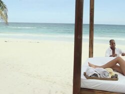 Man running on sandy beach to woman on bed Stock Footage