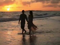 Good Looking Young Couple walking by the Sea at Sunset Stock Footage