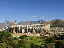 T/L new FIFA 2010 Cape Town Stadium under construction in Greenpoint with Table Mountain in background, South Africa Stock Footage