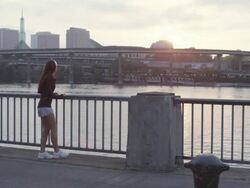 MS SLO MO Shot of young female jogger stands on water front facing city and begins her morning jog / Portland, Oregon, United States  Stock Footage