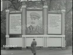 MOT 1946: SOVIET ZONE, GERMANY: STREET SCENES: Russian soldiers marching by building. HUGE Stalin painting billboard w/ Russian Cyrillic lettering side panels. VS Soviet officers in coats walking out guarded building, Headquarters Instructional Video