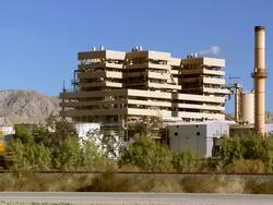 WS Cars moving on road and freight train moving on tracks in front of power plant / Thermal, California, USA Stock Footage
