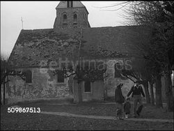 1947: FRANCE: DRAMATIZATION: 'DuBois family' walking path near country home. 'Cousin Amiel & wife' greet 'DuBois family' at door. SUNDAY DINNER: Cousin Amiel's family' & 'DuBois family'  at table, cutting chicken, opening wine, Instructional Video