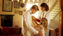Groomsman and flower girl helping groom get dressed before wedding Stock Footage
