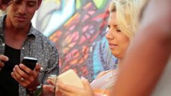 Brazilian friends look at smartphones and laugh Stock Footage