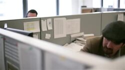 Trendy office worker in cubicle hangs up phone, sips coffee Stock Footage