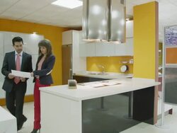WS TS salesman and female client discussing plans in kitchen showroom; while talking, they walk from one area of the showroom to another, the camera follows them Stock Footage