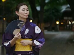MS Woman wearing yukata (Japanese traditional costume) is waiting in front of a shrine in / Tokyo, Japan Stock Footage