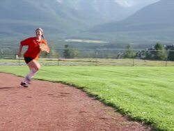 Female baseball player catches softball, mountain field Stock Footage
