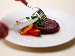 CU Hands cutting piece of steak on white backdrop / Seoul, South Korea Stock Footage