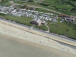 MS AERIAL PAN View of Tram moving along Ostende beach / Flanders, Belgium Stock Footage