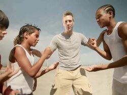 Boys doing rock, paper, scissors on beach Stock Footage
