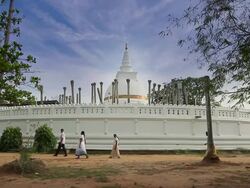 MS Worshippers passing Thuparama Dagoba, the first dagaba built in Sri Lanka after introduction of Buddhism, contains collarbone of Buddha / Anuradhapura, North Central Province, Sri Lanka Stock Footage