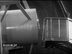 1953: PALOMAR OBSERVATORY: WS Open elevator lifting unidentified astronomer scientist up, walking into cylinder. BEHIND Astronomer setting up photographic plate, adjustable diaphram moving, exposing film. DAY: Telescope retracting. Astrophotography, Instructional Video