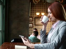 Woman in a cafe using tablet and drink coffee Stock Footage