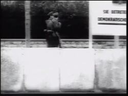 B/W 1961 two soldiers holding guns guarding Berlin Wall walking / Germany / newsreel Stock Footage