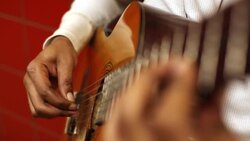 Musician's skilled fingers pick acoustic guitar on New York City subway platform Stock Footage