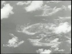 1944: CAROLINE ISLANDS BOMBING: VS Squadron of B-24 Liberator bombers of the Seventh Air Force (7th Air Force) flying, gunner inside, Thirteenth Air Force (13th Air Force) bombers flying, approaching Truk Islands, bombs away, explosions. WWII Instructional Video