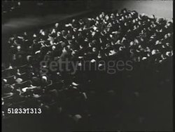 1940: FDR IN CHARLOTTESVILLE: President Franklin D. Roosevelt (1882-1945) behind podium, black BG: 'Overwhelmingly, we as a nation...gods of force & hate...democracy at stake...love of freedom still fierce' VS Auditorium. University of Virginia. WWII Instructional Video