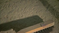 An archaeologist gently brushes dust away from a inscribed stone in Qift, Egypt. Stock Footage