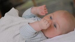 displeased baby showing a fist looking at camera Stock Footage