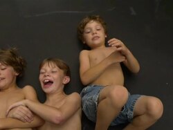 MS SLO MO shot of head and shoulders of three caucasian male kids on trampoline, lying on back being bounced / Stanford, Connecticut, United States Stock Footage
