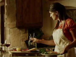 Medium panning shot of woman drizzling olive oil and vinegar over salad / Cedar Hills, Utah, United States Stock Footage