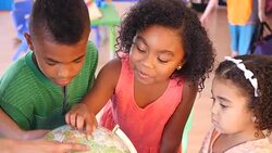 A group of African American children examine globe at daycare Stock Footage