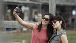 Two young women pose for a smartphone selfie in Texas ghost town Stock Footage