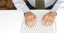 Businessman hands typing on keyboard on white table background Stock Footage