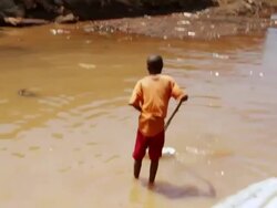 MS Shot of local child playing in drain water and local life / Freetown, Sierra Leone Stock Footage