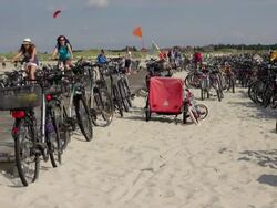 WS Shot of parked bicycle and people riding bicycle at beach near cafe, North Sea North Frisia, / St. Peter Ording, Schleswig Holstein, Germany Stock Footage