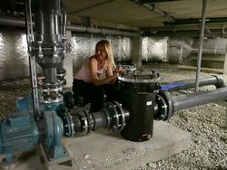 Bizarre engineer thinking happily while relaxing among water pumps Stock Footage