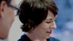 Hip young businessman and older businesswoman crack each other up in corporate boardroom Stock Footage