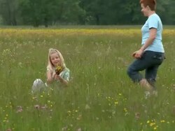 CRANE: Little girl picking flowers Stock Footage