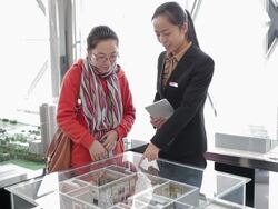 MS Shot of Visitor and saleswoman talking about apartment models in real estate sales center / Xi'an, shaanxi, China  Stock Footage