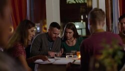 Group of friends look over and discuss dinner menus in gourmet restaurant Stock Footage