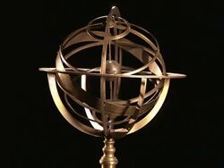 An armillary sphere slowly rotates against a black background. Stock Footage