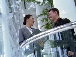 Low angle medium shot businesswoman talkling to businessman on office balcony Stock Footage