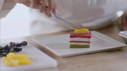 Baker delicately garnishes gourmet cake with tangerine slices Stock Footage