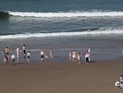 PEOPLE PLAYING IN SEA AND ON BEACH Stock Footage