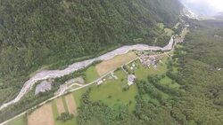 POV wingsuit flying over cliffs and alpine forests releasing parachute Stock Footage