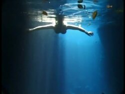 Snorkler swimming in sunbeams through water, MS, Tonga Stock Footage