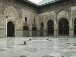 MS Shot of ornate courtyard in Madrasa Bou Inania and cat walking across courtyard towards / Fez, Fes-Boulemane, Morocco Stock Footage
