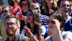 MS Woman stomping feet and clapping with crowd during football game in stadium Stock Footage