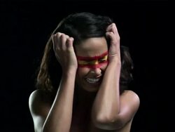 Woman with red and yellow face paint with head in hands Stock Footage