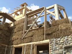 MS ZI Carpenter stacking bales of straw during  framing of an energy efficient post / Grass Lake, Michigan, USA      Stock Footage