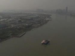 Wide angle aerial view of multiple barges sailing along river through Shanghai, China Stock Footage