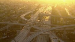 Stunning aerial shot of a Los Angeles freeway interchange bathed in afternoon sunlight. Stock Footage